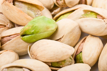 Several pistachio nuts naked and in shell close up