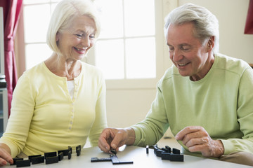 Couple playing dominos in living room smiling
