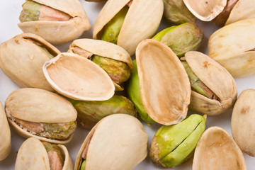 Several pistachio nuts naked, empty shells  and in shell close u