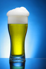 Glass of beer over blue background