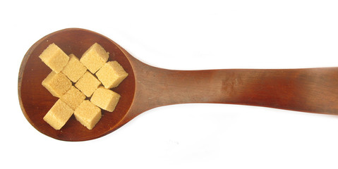 Sugarcubes brown sugar in wooden spoon 