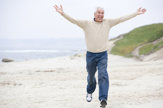 Man at the beach running and smiling
