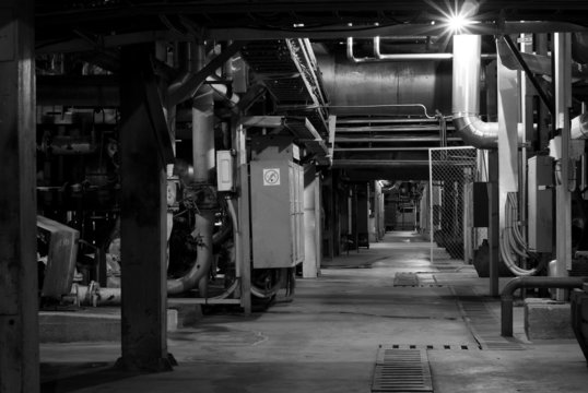 Machinery, pipes, and boilers at factory black and white