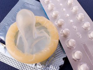 Birth Control Pills and a Condom. Contraception methods...