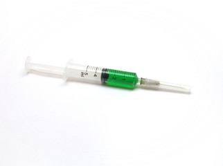 Syringe containing green solution on white blackground