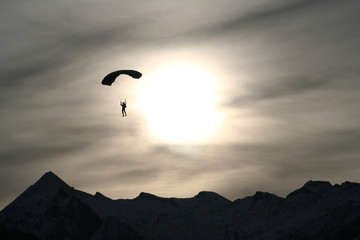 Fallschirmspringer über Alpenwipfeln