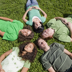 Fototapeta premium Five teens in lie in the grass