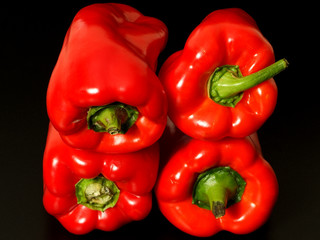 Top view of wet red peppers on black background