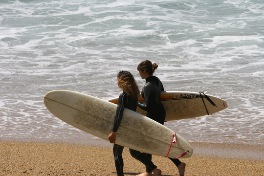 jeune fille qui marchent  avec leurs planches de surf