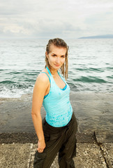 Wet girl standing near the ocean