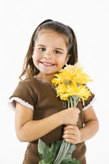 Little smiling hispanic girl with flowers.