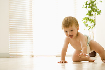 Baby crawling indoors smiling