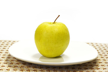 Apple on the white plate isolated