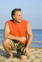 A happy laughing forties man on beach