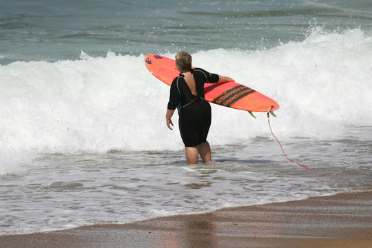 personne en surpoids qui va faire du surf