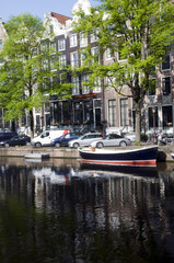 Fototapeta na wymiar canal with boats and homes amsterdam holland