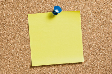 Yellow remainder note on cork background, with blue pin.