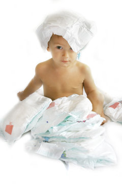 baby boy playing with diapers over white