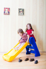 Two adorable girls having fun atop playground slide
