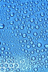 Water droplets on glass to colored background