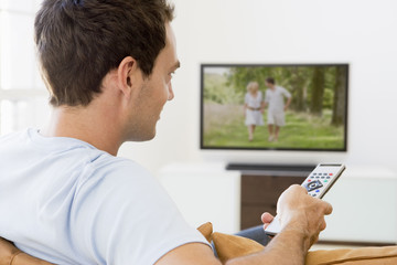 Fototapeta premium Man in living room watching television
