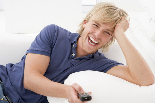 Man In Living Room Holding Remote Control Laughing