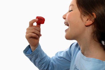 Young girl eats strawberry
