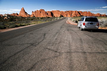 car in the Road in the desert, Arches National Park in Utah, USA