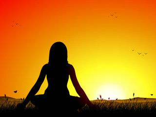 Girl doing yoga on a filed at sunset