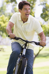 Man outdoors riding bike smiling