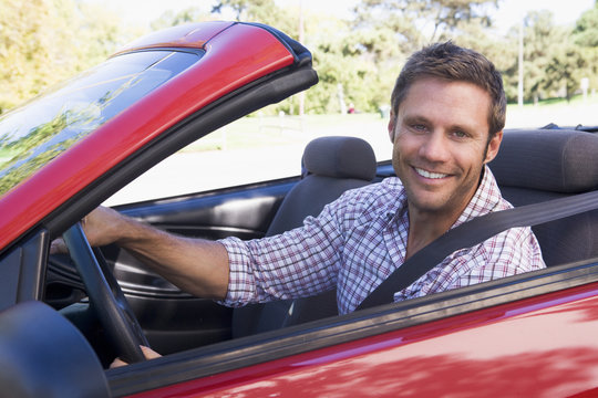 Man in convertible car smiling