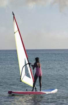 Young asian girl learning to windsurf