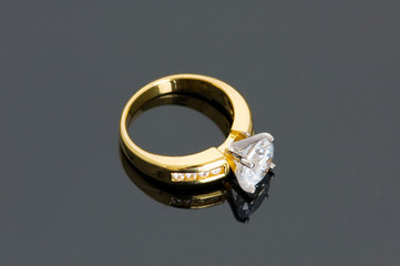 Gold diamond ring on the reflective background