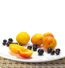 Ripe apricots and currant on a plate