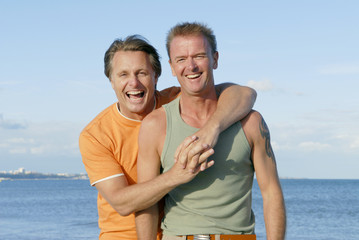 Fototapeta na wymiar Para gejów zabawy na plaży razem.