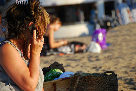 femme qui t&eacute;l&eacute;phone sur la plage