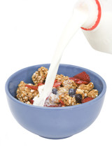 pouring milk in a bowl with cereal
