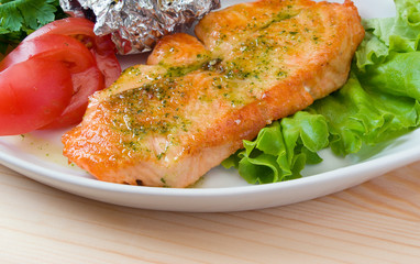 Stake from a salmon with vegetables . Closeup.