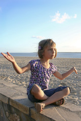 Fototapeta na wymiar fillette sur le front de mer - yoga