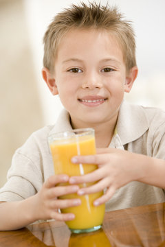 Young boy with orange juice smiling