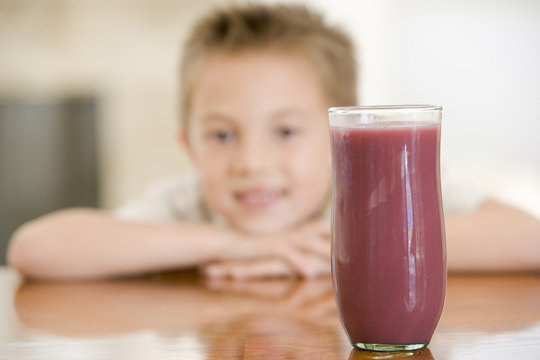Young boy with focus on juice glass