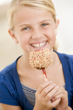 Young Girl Eating Candy Apple Smiling