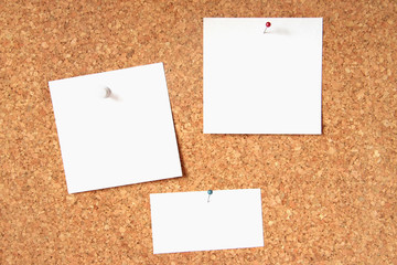 Three blank cards pinned to a cork board