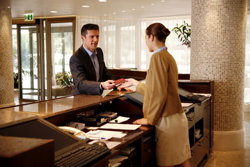 Man checking in  at the hotel reception desk