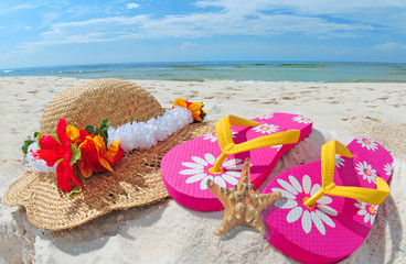 Flipflops and hat on shore