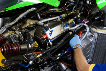 mechanic working on racing car engine - obrazy, fototapety, plakaty