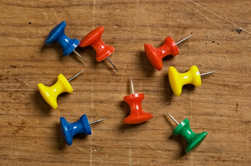 assorted pushpins on different colors on wooden board.