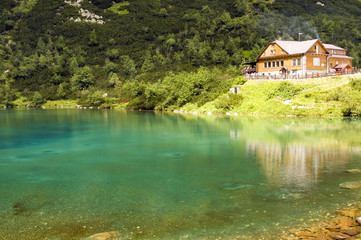 Fototapeta na wymiar Chalet obok zielony górskie jeziora