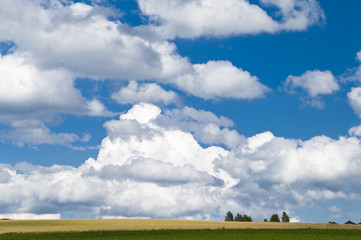 Sommerlandschaft mit kr&auml;ftigen Wolken