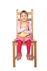 girl with toy sitting on stool